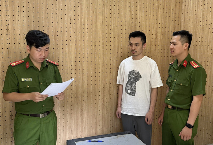 Công an tống đạt các quyết định khởi tố và bắt tạm giam đối với Đặng Tùng Lâm - Ảnh: CAO THIÊN
