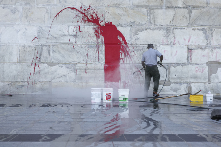 Nhân viên lau chùi, tẩy vết sơn đỏ vẽ bậy lên Đài tưởng niệm Washington ở Mỹ - Ảnh: GETTY IMAGES