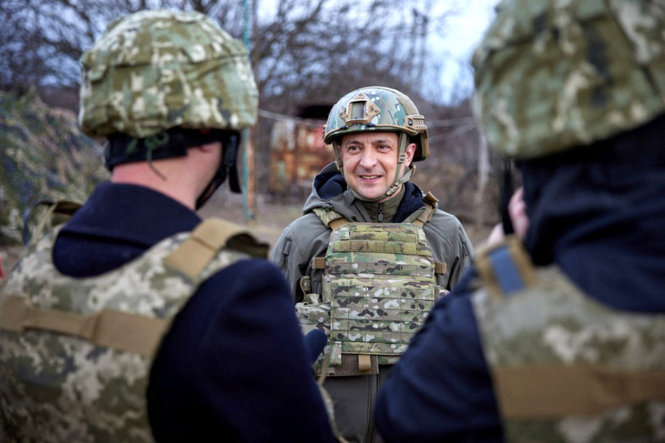 Tổng thống Ukraine Volodymyr Zelensky tươi cười trò chuyện với các binh sĩ ở mặt trận Mariupol, khi ông có dịp ghé thăm tiền tuyến hồi đầu tháng 4 - Ảnh: AFP