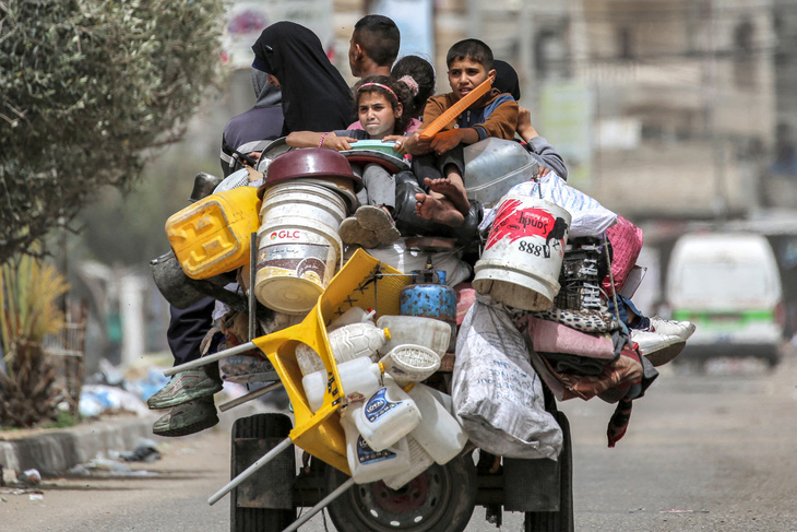 Gia đình người Palestine chạy khỏi thành khố Khan Younis (Dải Gaza) trên một chiếc xe ba gác - Ảnh: AFP