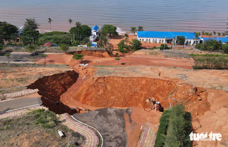 Một mảng cát đỏ trên đồi cao dự án Sentosa Mũi Né bị xé toạc, trôi xuống phía dưới làm ngập đường, chôn xe - Ảnh: ĐỨC TRONG