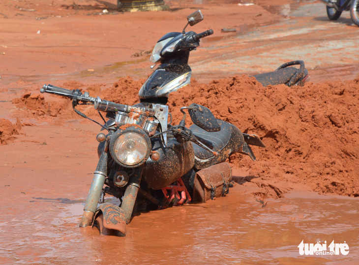 Nhiều người đi chỉ kịp chạy thoát thân, bỏ lại xe máy bị chôn vùi dưới lớp bùn cát đỏ - Ảnh: ĐỨC TRONG