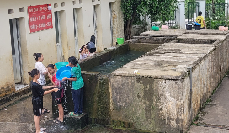 Học sinh Trường phổ thông dân tộc nội trú THCS Mường Lát tắm chung tại bể nước cạnh ký túc xá - Ảnh: HÀ ĐỒNG