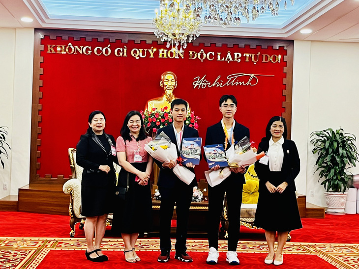 Hai học sinh đạt giải nhận hoa từ các giáo viên Trường THPT chuyên Lê Hồng Phong - Ảnh: MỸ DUNG
