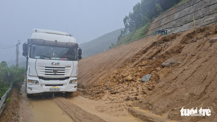 Đất đá theo nước mưa sạt xuống bên dưới phần đường lưu thông theo hướng từ Bình Định lên Gia Lai trên quốc lộ 19 qua đèo An Khê, khiến các phương tiện gặp rất nhiều khó khăn (ảnh chụp chiều 21-5-2024) - Ảnh: LÂM THIÊN