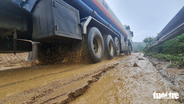 Bùn đất theo nước mưa trôi xuống đường khiến các phương tiện qua đèo An Khê gặp khó khăn, nguy hiểm - Ảnh: LÂM THIÊN