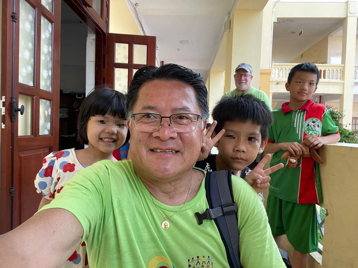 Ông Sơn Michael Phạm (trưởng đoàn) chụp ảnh lưu niệm với các trẻ kém may mắn ở Hải Phòng - Ảnh: NVCC