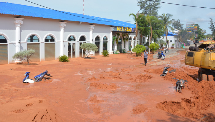 Nhiều nhà hàng, xe cộ người dân bị chôn lấp do cát đỏ tràn từ dự án Sentosa Villa Mũi Né, tỉnh Bình Thuận lúc rạng sáng 21-5 - Ảnh: ĐỨC TRONG