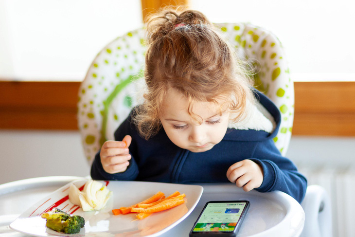 Trẻ em sử dụng điện thoại thông minh trong bữa ăn sẽ tăng nguy cơ béo phì- Ảnh 1.