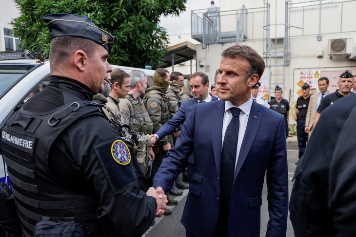 Tổng thống Pháp Emmanuel Macron bắt tay với lực lượng an ninh đảo New Caledonia ngày 23-5 - Ảnh: REUTERS