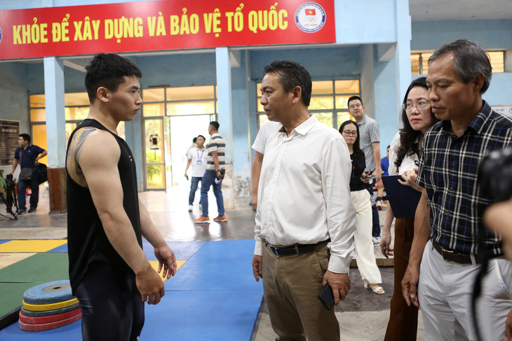 Thứ trưởng Hoàng Đạo Cương (áo trắng) hỏi thăm đô cử Trịnh Văn Vinh (bìa trái) tình hình chuẩn bị cho Olympic 2024 - Ảnh: HOÀNG TÙNG