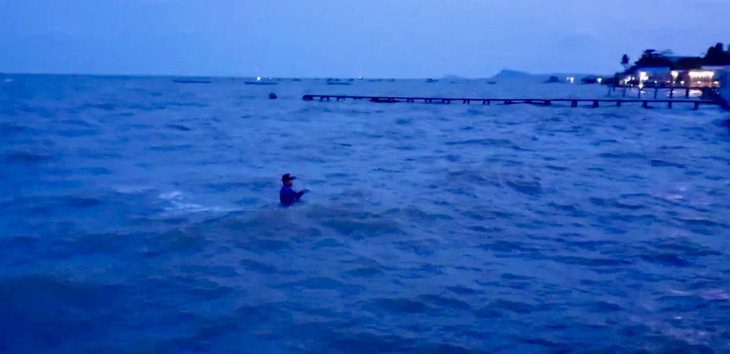 Biển đêm khu cầu cảng Hàm Ninh chỉ còn cảnh ngư dân ngụp lặn lần mò từng bước lội từ ghe vào - Ảnh: DUY KHÁNH