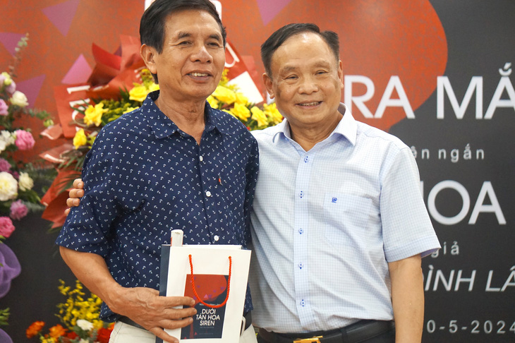 Tác giả Nguyễn Đình Lâm (phải) chụp ảnh lưu niệm cùng độc giả trong buổi ra mắt sách - Ảnh: T.ĐIỂU