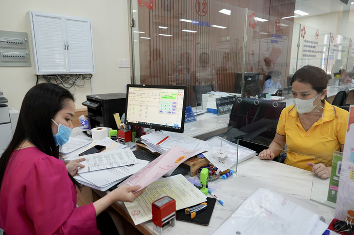 Cán bộ UBND quận Tân Phú, TP.HCM đóng dấu chứng thực các loại giấy tờ cho người dân - Ảnh: HỮU HẠNH