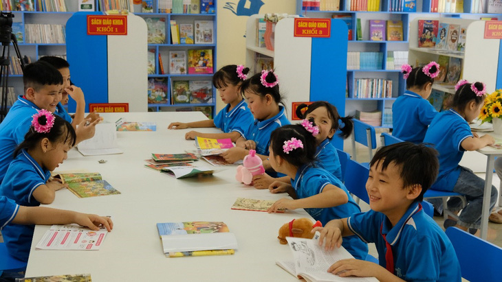 Các em học sinh hân hoan đọc sách tại thư viện mới