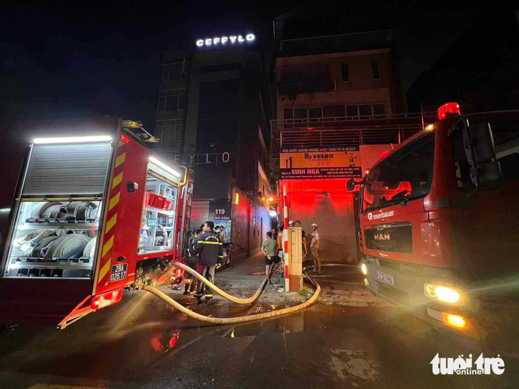 Cảnh sát phải kéo đường ống dẫn nước từ ngoài phố Trung Kính vào sâu trong ngõ để dập lửa trong vụ cháy rạng sáng 24-5 - Ảnh: MINH THANH