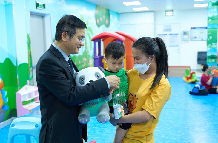 Ông Nguyễn Quang Trí - Giám đốc Điều hành Vinamilk, tặng quà cho các gia đình, các bé đến tiêm ngừa tại Trung tâm VNVC trong ngày kí kết hợp tác. Ảnh: Vi Nam