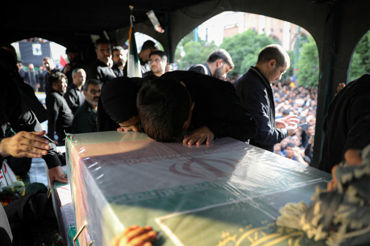 Một người đưa tang cúi đầu trước quan tài cố Tổng thống Raisi ngày 23-5 - Ảnh: REUTERS