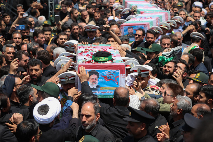Người dân Iran tiếc thương đặt tay lên quan tài để tiễn đưa cố tổng thống Iran lần cuối, ngày 23-5 - Ảnh: REUTERS