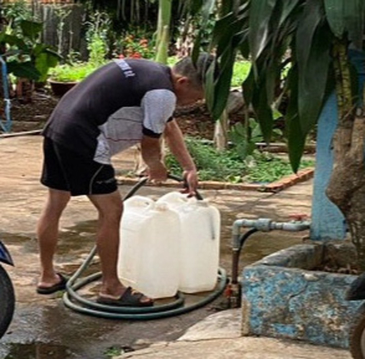 Người dân huyện Chư Sê phải xách can đi xin nước sinh hoạt do nhà máy nước nợ tiền điện, bị cắt điện sản xuất, dẫn đến không cấp nước được cho khách hàng - Ảnh: V.T. 