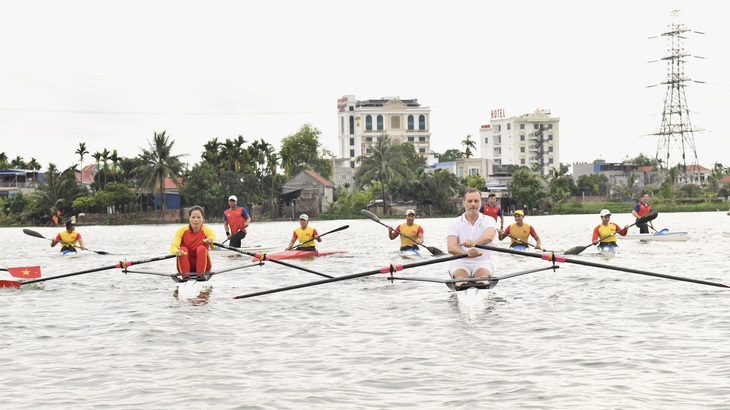 Đại sứ Pháp Olivier Brochet (áo trắng) giao lưu đua thuyền cùng các vận động viên đã giành suất dự Olympic và đội tuyển đua thuyền Việt Nam - Ảnh: LĐĐTVN