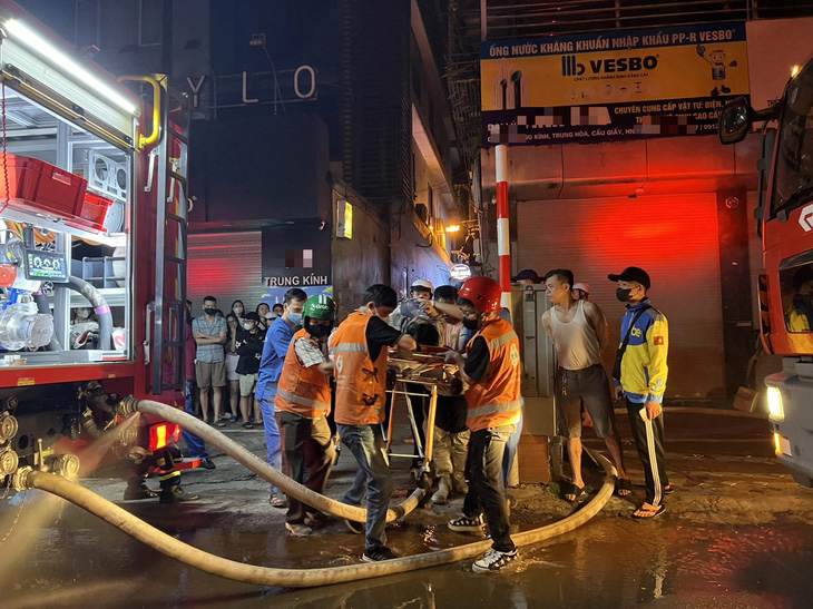 Lực lượng chức năng đưa các nạn nhân ra khỏi đám cháy - Ảnh: MINH THANH