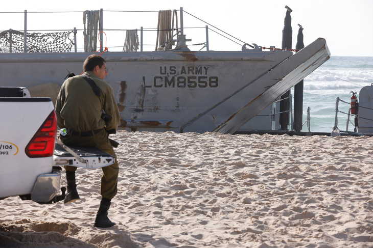 Một tàu của Mỹ mắc cạn bên phần bờ biển Israel, đang được binh sĩ Israel hỗ trợ - Ảnh: REUTERS