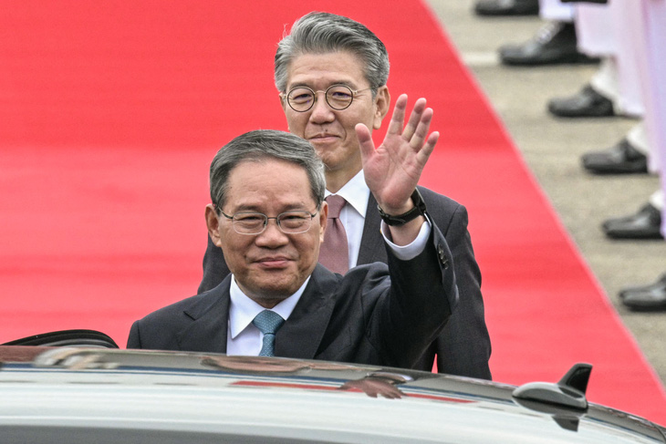 Thủ tướng Trung Quốc Lý Cường vẫy tay chào khi đến Seoul dự hội nghị cấp cao ba bên ở Seoul ngày 26-5 - Ảnh: AFP