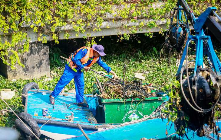 Công nhân vất vả vớt rác thải trên kênh Nhiêu Lộc - Thị Nghè - Ảnh: CHÂU TUẤN