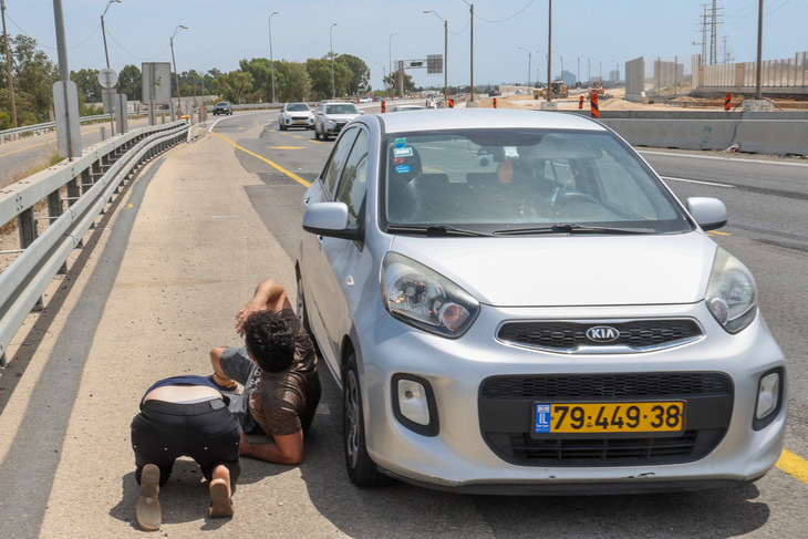 Người dân Israel nằm xuống đất nấp khi rocket của Hamas phóng vào Tel Aviv, ngày 26-5 - Ảnh: AFP