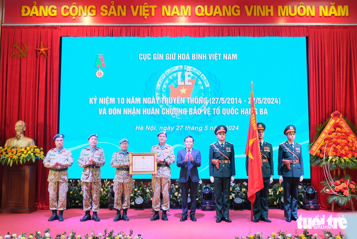 Thừa ủy quyền của Chủ tịch nước, Phó thủ tướng Trần Lưu Quang trao Huân chương Bảo vệ Tổ quốc hạng ba cho Cục Gìn giữ hòa bình Việt Nam - Ảnh: HÀ THANH