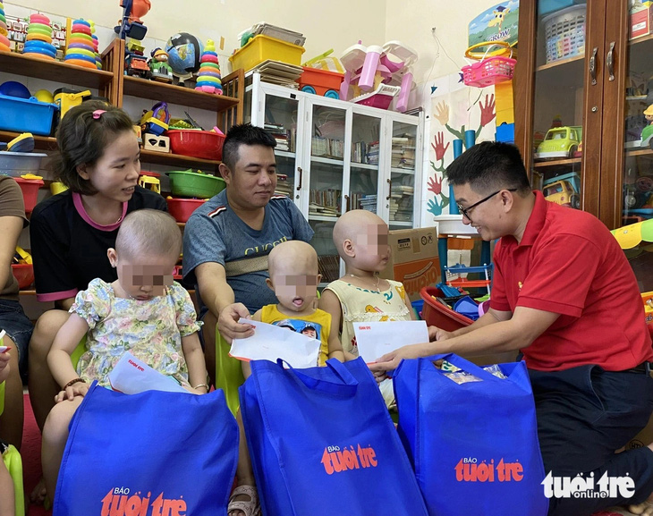 Đại diện báo Tuổi Trẻ (phải) trao quà cho bệnh nhi tại Bệnh viện Phụ sản - nhi Đà Nẵng - Ảnh: TRƯỜNG TRUNG