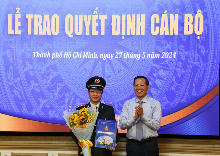 Chủ tịch UBND TP.HCM Phan Văn Mãi trao quyết định nghỉ hưu cho ông Đặng Minh Đạt - Ảnh: THẢO LÊ 