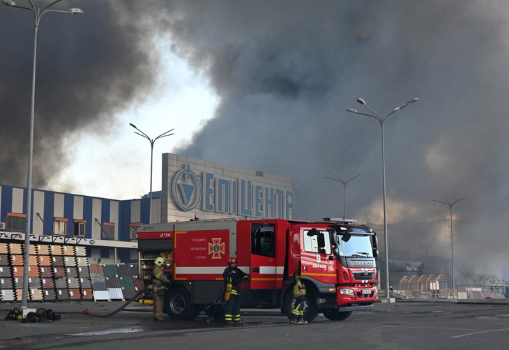 Lính cứu hỏa Ukraine nỗ lực dập tắt đám cháy tại một siêu thị sau cuộc tấn công của Nga ở Kharkov, Ukraine hôm 25-5 - Ảnh: AFP