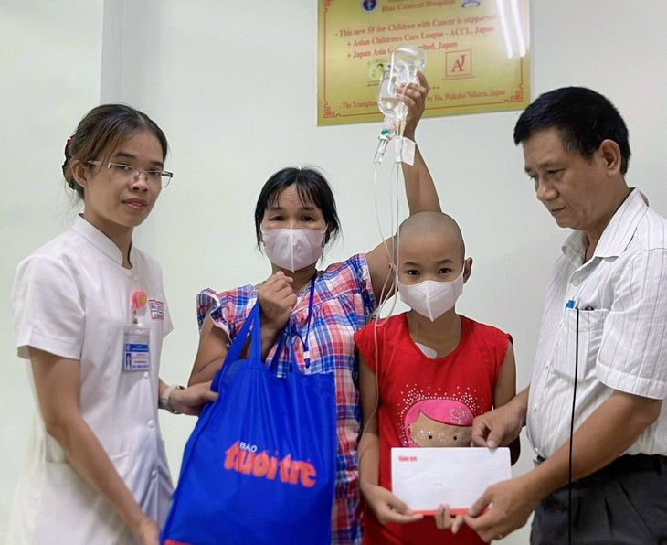 Đại diện báo Tuổi Trẻ (bìa phải) trao quà cho bệnh nhi ung thư tại Trung tâm nhi khoa - Bệnh viện Trung ương Huế - Ảnh: BẢO PHÚ