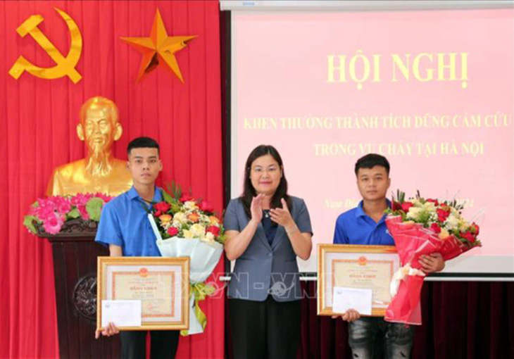 Lãnh đạo UBND tỉnh Nam Định trao bằng khen cho 2 thanh niên dũng cảm cứu người trong vụ cháy rạng sáng 24-5 tại Hà Nội - Ảnh: TTXVN
