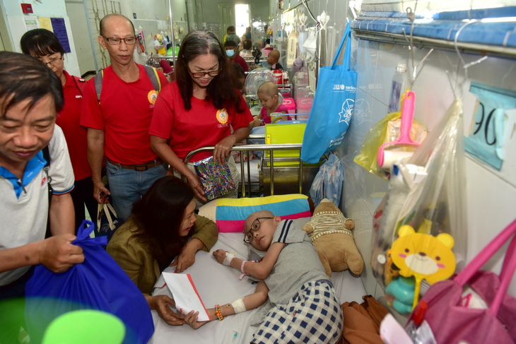 Đại diện báo Tuổi Trẻ trao quà cho bé Nguyễn Lâm Đức Phú (9 tuổi, Nhà Bè, TP.HCM) đang được điều trị tại Bệnh viện Nhi đồng 2 sáng 28-5 - Ảnh: T.T.D.