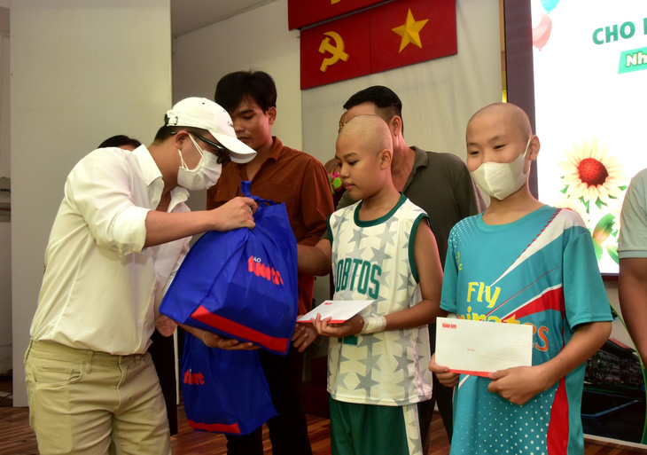 Anh Hà Thanh Phúc, đại diện phòng trà Bến Thành, trao quà cho bệnh nhi ung thư tại Bệnh viện Nhi đồng 2 sáng 28-5 - Ảnh: T.T.D.