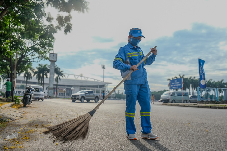 Công việc của công nhân môi trường ở Hà Nội vất vả dù là nắng nóng hay mưa rơi - Ảnh: HÀ QUÂN