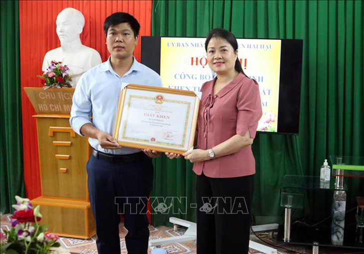 Lãnh đạo UBND huyện Hải Hậu tặng Giấy khen cho thầy giáo Nguyễn Trọng Tài cứu học sinh đuối nước sáng ngày 27-5 - Ảnh: TTXVN 