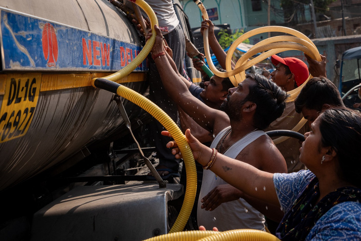 Người dân Ấn Độ tập trung để lấy nước dưới thời tiết nắng nóng như thiêu đốt của thủ đô New Delhi, Ấn Độ, ngày 18-5 - Ảnh: AFP