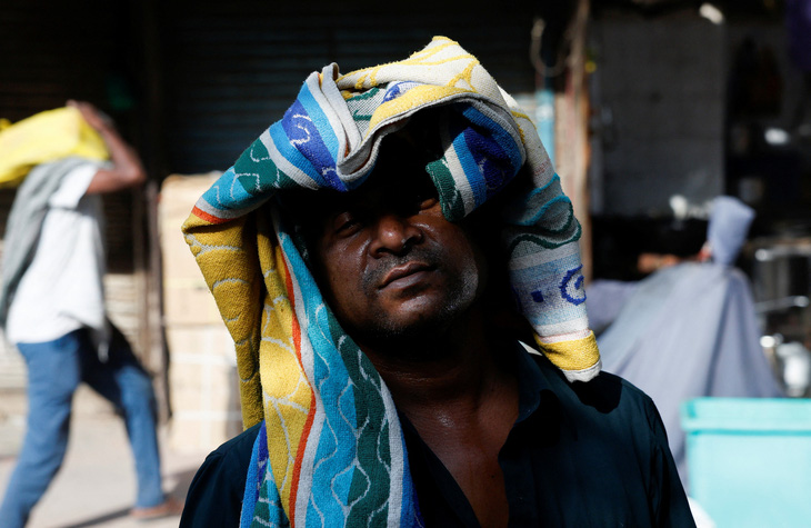 Một người đàn ông Ấn Độ lấy khăn đội lên đầu để tránh sốc nhiệt tại thủ đô New Delhi, ngày 28-5 - Ảnh: REUTERS