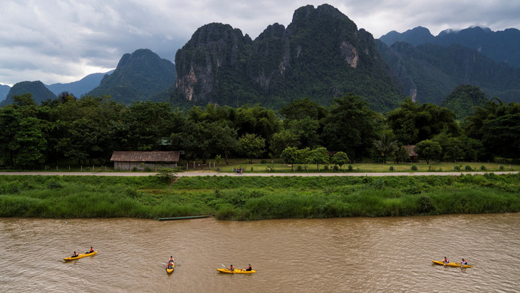 Du khách chèo thuyền kayak trên sông ở Vang Vieng, Lào hồi tháng 7-2022 - Ảnh: REUTERS