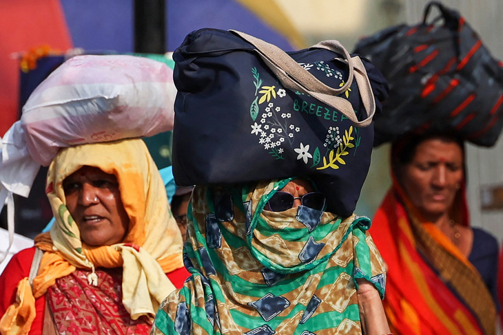 Những người phụ nữ trùm kín để tránh nóng tại thành phố Varasani, Ấn Độ, ngày 27-5 - Ảnh: AFP