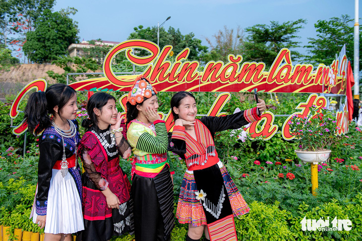 Nhóm học sinh Trường THPT Phan Đình Giót với trang phục dân tộc mình chụp ảnh tại vườn hoa trang trí trên đường 7-5 mới được khánh thành