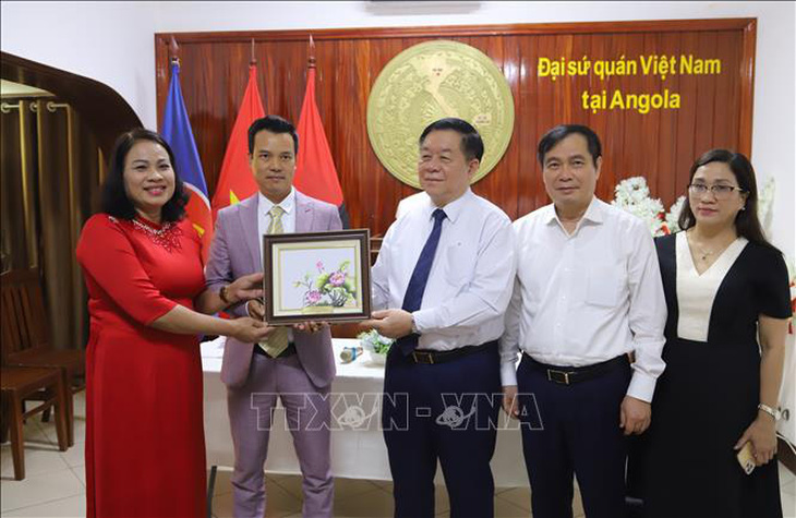 Trưởng Ban Tuyên giáo Trung ương Nguyễn Trọng Nghĩa tặng quà lưu niệm cho đại diện cộng đồng người Việt Nam tại Angola - Ảnh: TTXVN