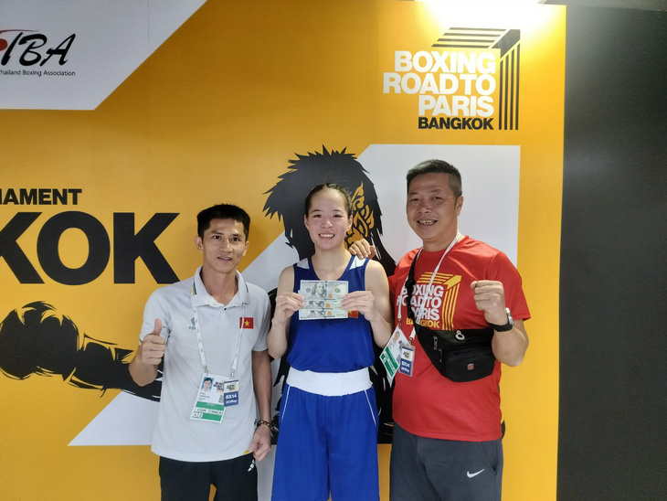 Nữ võ sĩ Nguyễn Huyền Trân (giữa) nhận thưởng nóng từ ban huấn luyện đội tuyển boxing Việt Nam - Ảnh: TT2