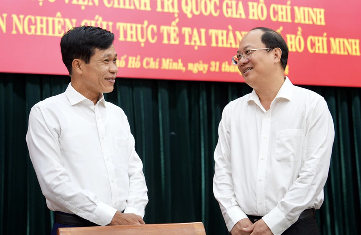 Ông Hoàng Phúc Lâm, phó giám đốc Học viện Chính trị quốc gia Hồ Chí Minh, trao đổi cùng Phó bí thư thường trực Thành ủy TP.HCM Nguyễn Hồ Hải - Ảnh: HỮU HẠNH