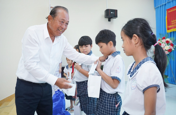 Ông Trương Hòa Bình, nguyên ủy viên Bộ Chính trị, nguyên Phó thủ tướng Thường trực Chính phủ, tặng quà cho các em học sinh tại chương trình "Cùng ngư dân thắp sáng đèn trên biển" - Ảnh: M.T.