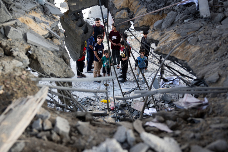 Những người Palestine bên cạnh hiện trường một vụ tấn công của Israel tại Dải Gaza hôm 3-5 - Ảnh: AFP
